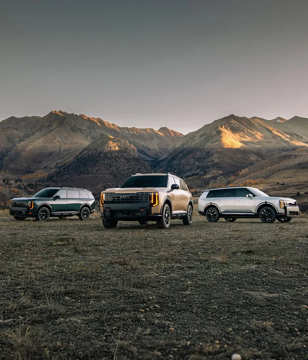 Three 2027 Kia Telluride SUVs parked in a mountain meadow.