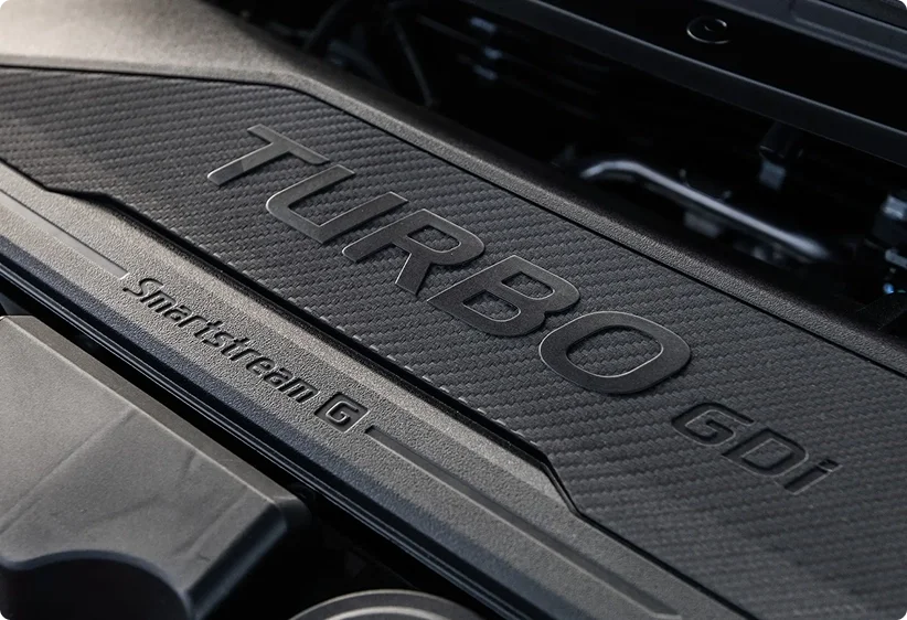 Close-up of the Smartstream turbocharged engine cover in the 2026 Kia K4 GT-Line Turbo, stamped TURBO GDi