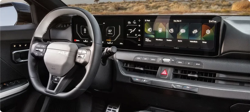 2026 Kia K4 steering wheel and dual 12.3-inch panoramic displays showing vehicle and infotainment information