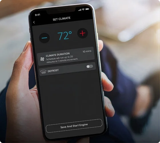 Hand holding a smartphone showing the Kia Access app climate screen set to 72 degrees