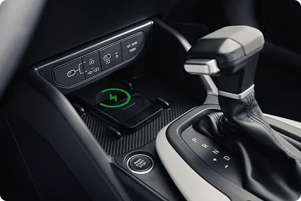 2026 Kia K4 center console close-up with the wireless charging pad and gear selector