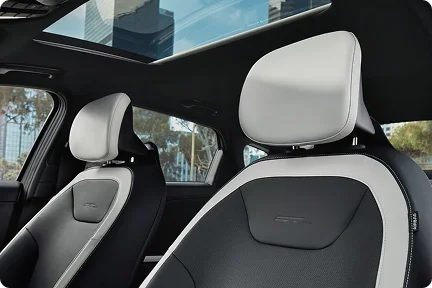 2026 Kia K4 front seats in two-tone black and white upholstery seen beneath the open ultra-wide sunroof