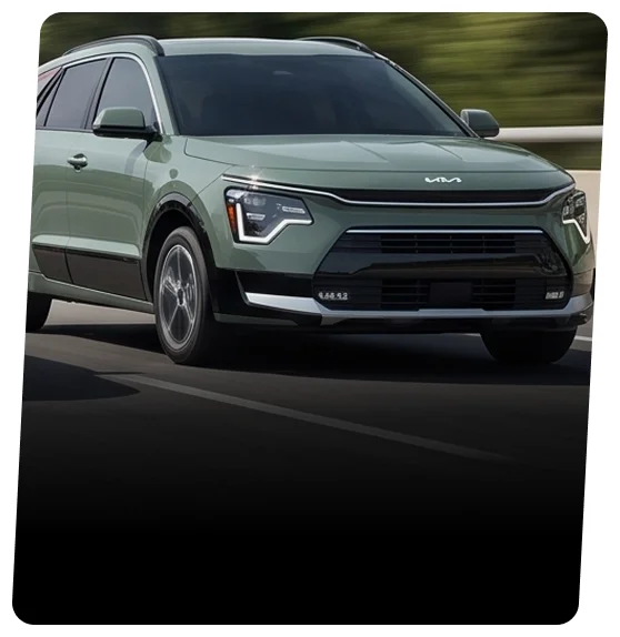 Sage green Kia Niro hybrid shown from the front three-quarter view on a highway