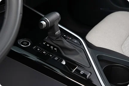 2026 Kia Niro Hybrid center console with the gear selector and drive mode buttons beside light gray upholstery