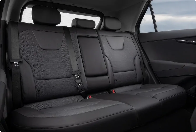 2026 Kia Niro Hybrid rear bench seat in black cloth upholstery seen through the open rear door