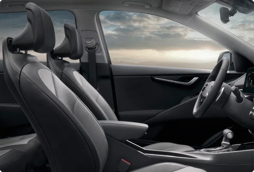 2026 Kia Niro Hybrid front seats in SynTex trim seen from outside the passenger window at dusk