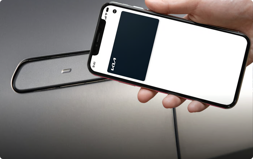 Hand holding a smartphone acting as a Digital Key 2.0 next to a key fob