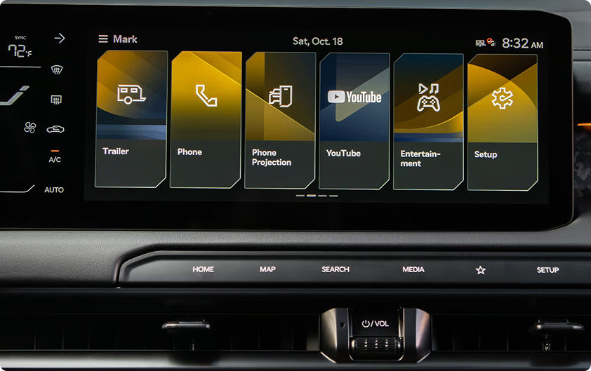 Infotainment touchscreen showing app tiles including Phone Projection, YouTube, and Entertainment