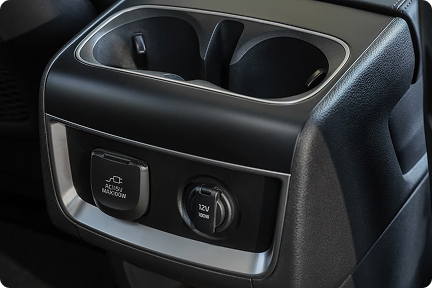 Close-up of the Carnival MPV's rear cup holders and seat control buttons