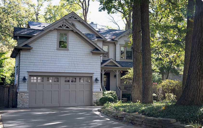 Suburban home with a closed two-car garage door controlled by Kia myQ
