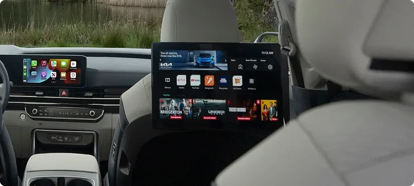 Rear seat entertainment screen showing streaming app tiles, mounted behind a front seat