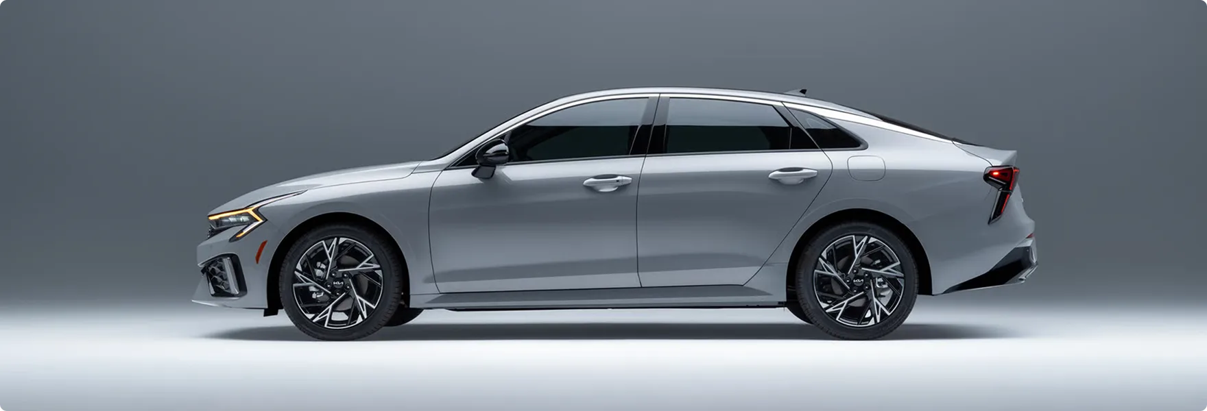 Silver 2027 Kia K5 shown in profile in a studio