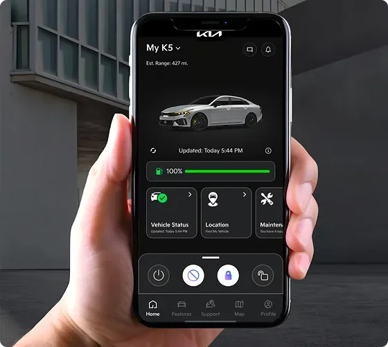 Hand holding a smartphone showing the Kia Connect app