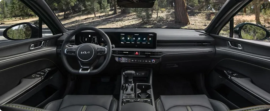 Kia K5 front cabin with upscale finishes and a panoramic sunroof