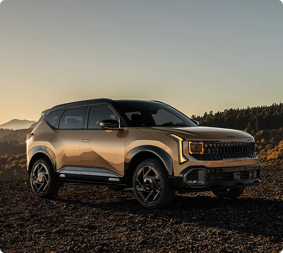 Bronze 2027 Kia Seltos on a hilltop at dusk, front three-quarter view