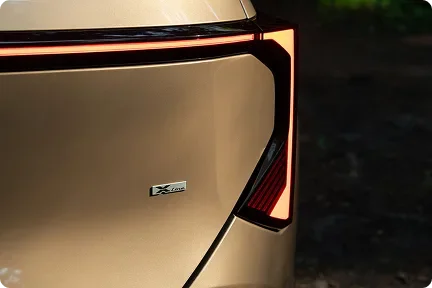 Close-up of a lit Seltos tail light and X-Line badge on a bronze body