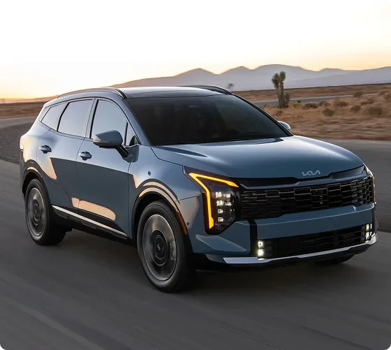 Blue 2027 Kia Sportage Hybrid at dusk with its vertical LED headlights and amber daytime running lights lit