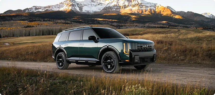 Dark green Telluride Hybrid front three-quarter at sunrise with mountains behind