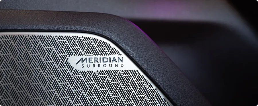 Close-up of a Meridian Surround speaker grille badge on the Telluride Hybrid trim