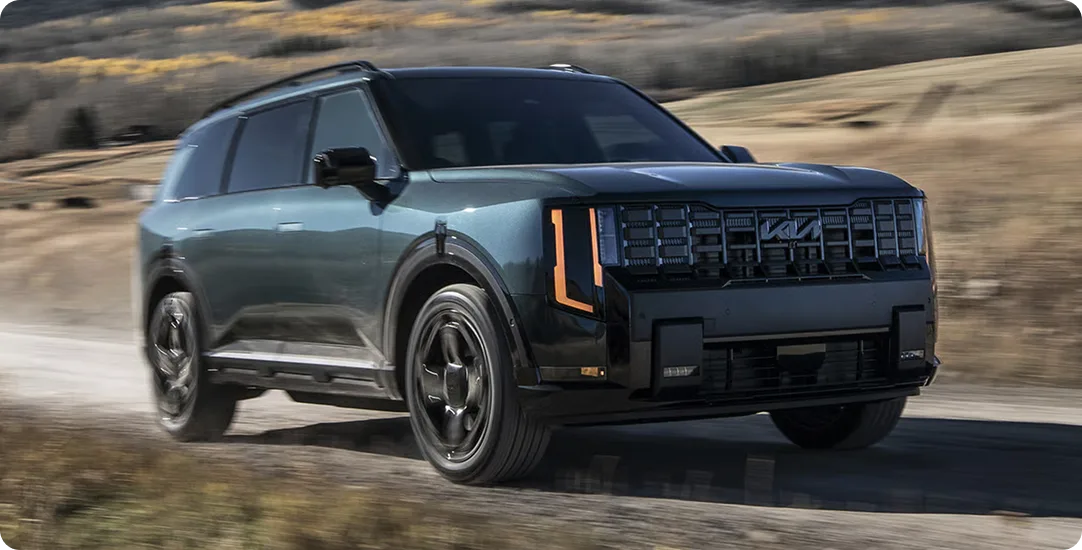 Dark Telluride Hybrid driving a dirt track through open country