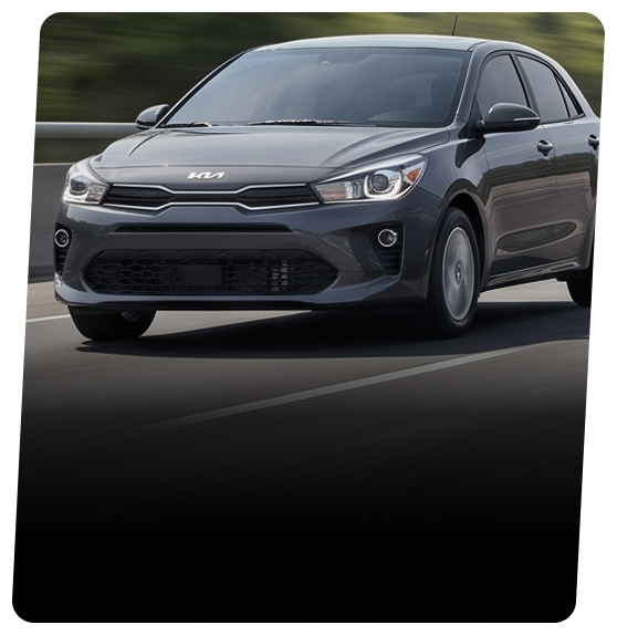 Dark grey Kia hatchback on an open road