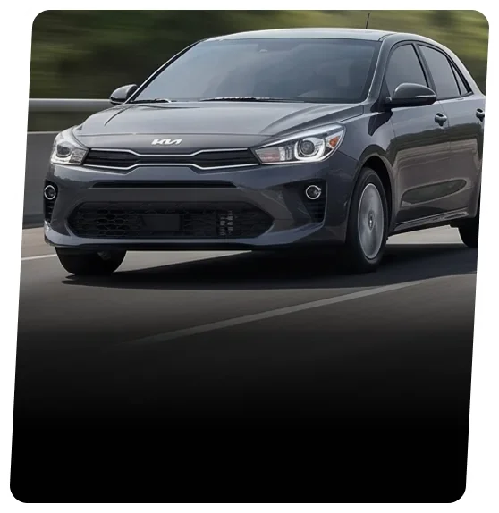 Dark grey Kia hatchback on an open road