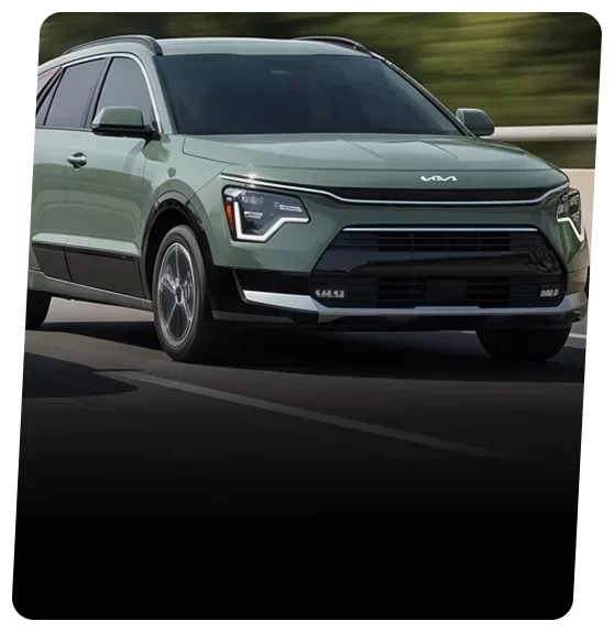 Green Kia Niro hybrid crossover on a city street