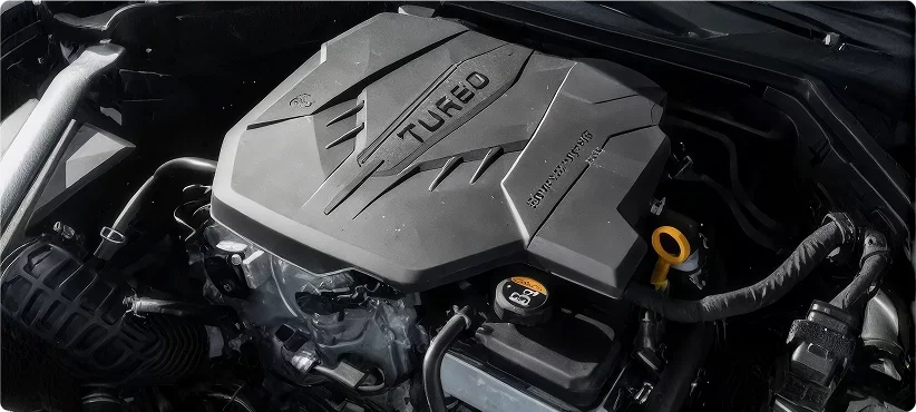 Kia engine bay with a black turbocharged engine cover and yellow oil dipstick