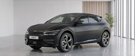 Dark grey Kia EV6 electric crossover in a bright studio showroom