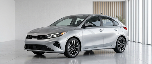 Silver Kia hatchback in a bright studio showroom