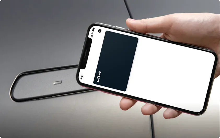 Hand holding a smartphone showing a digital key card beside the Telluride door handle