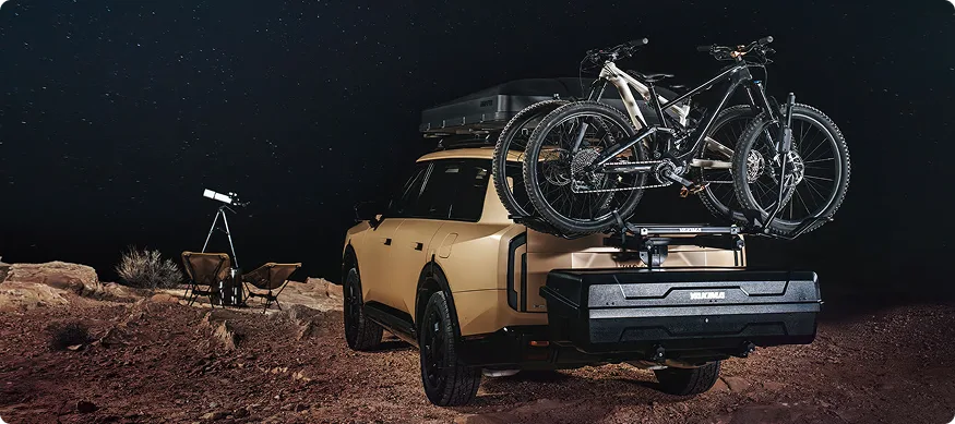 Bronze Telluride at night in the desert with bicycles on a rear rack and a telescope set up
