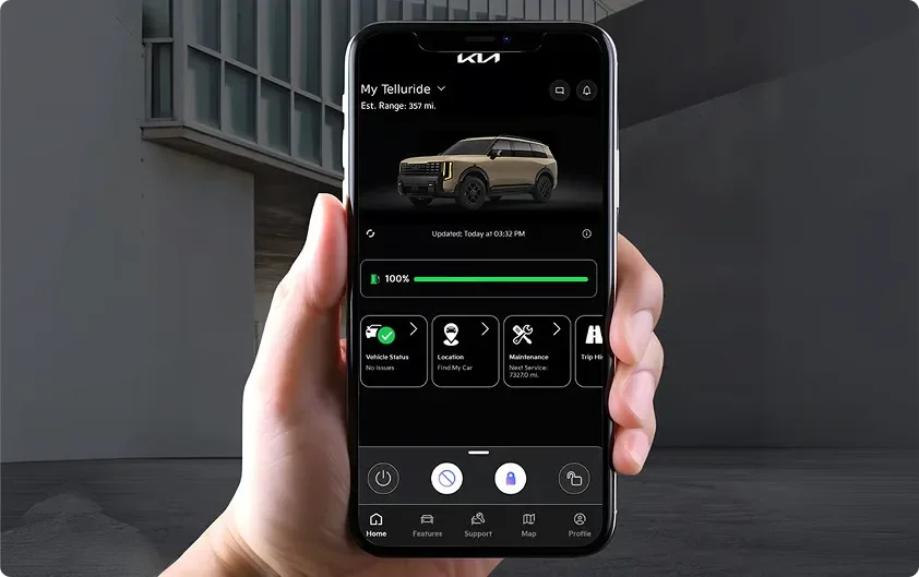 Hand holding a smartphone running the Kia app, showing My Telluride and its estimated range