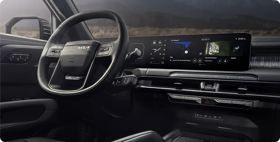 Telluride cabin with the steering wheel and dual displays, mountains through the windshield