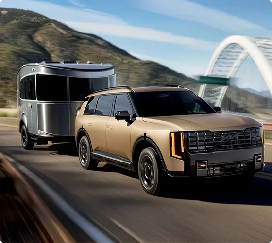 Bronze Telluride towing a silver travel trailer along a highway